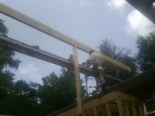 Carpenter setting a ridge beam over a new addition frame — Ice Dam Removal by Roofing Brothers in Cardwell