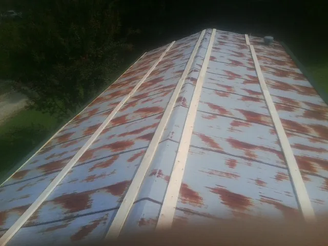 Rusted metal roof panels with new wood purlins before replacement — Storm Damage Roof Repair in Cardwell by Roofing Brothers
