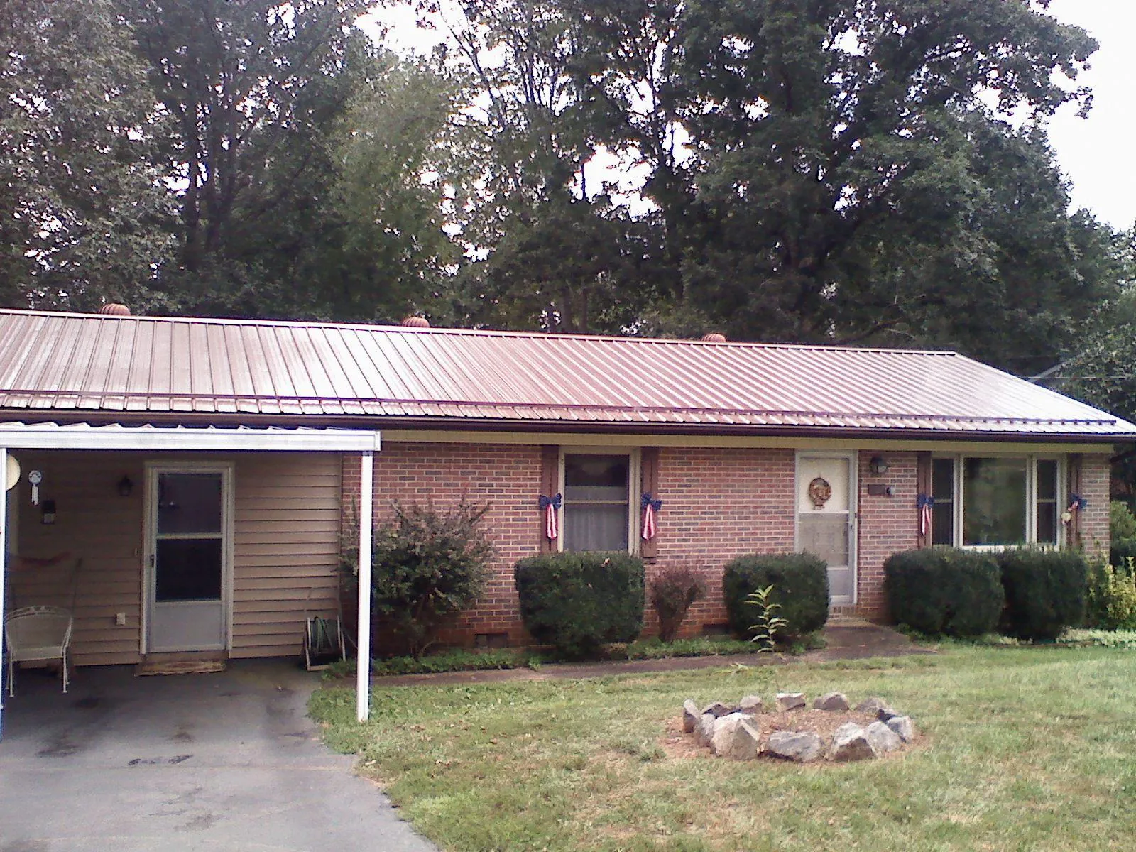 Bronze metal roof and carport on a brick ranch home — Roof Repair work by our crew in Cardwell